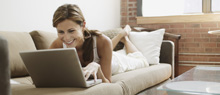 Lady laying on the couch with her laptop