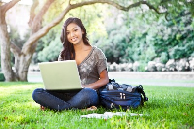 Student sitting in the commons area outside on her computer