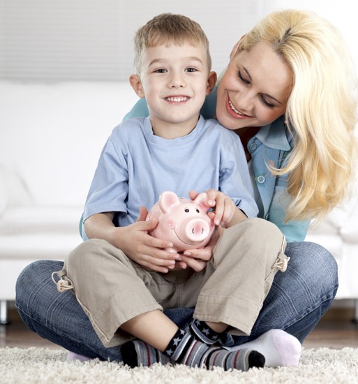 Mom and son sitting on the floor holding a piggy bank