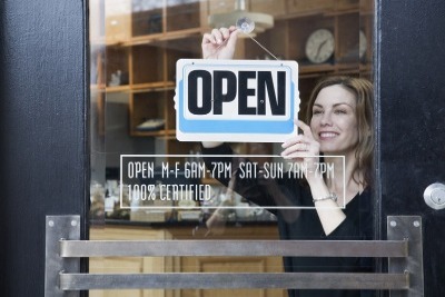 Putting up the Open sign in a business window 