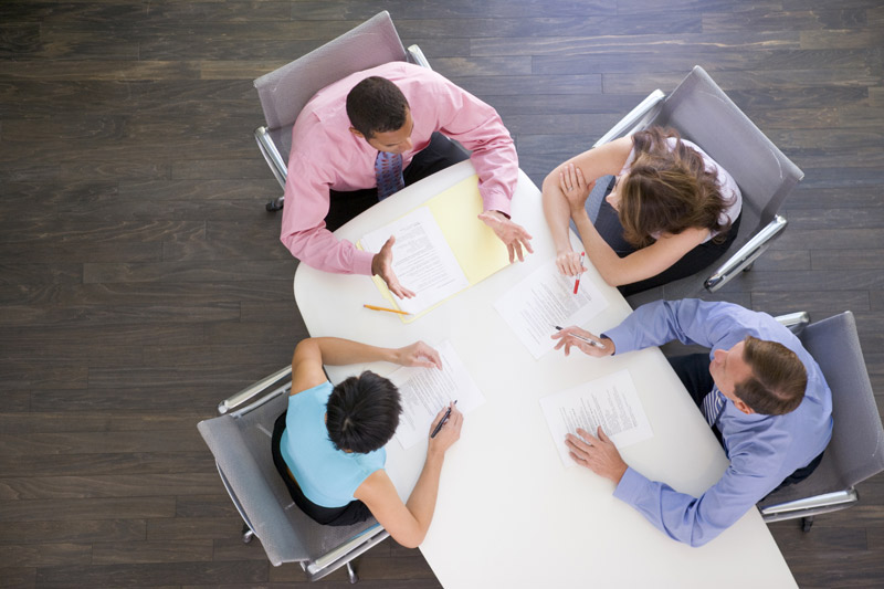 4 people sitting around a table for a meeting 